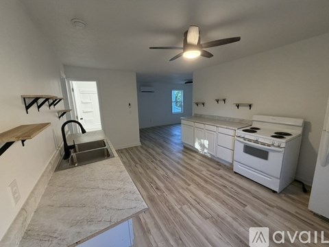A kitchen with a white stove and a fan on the ceiling.