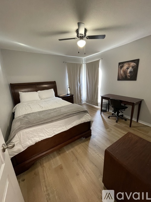 A bedroom with a bed, desk, and chair.