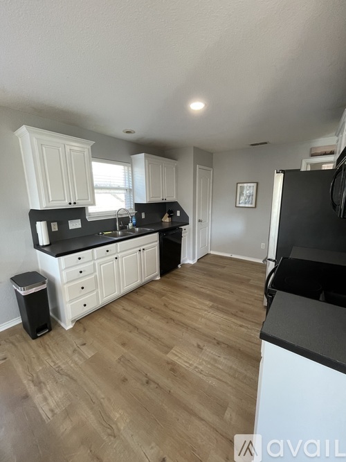 A kitchen with black countertops and white cabinets.