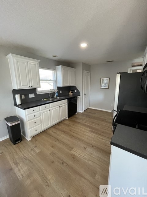 A kitchen with black countertops and white cabinets.