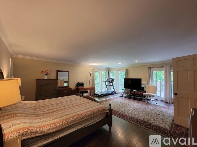A bedroom with a large bed and a television in the corner.