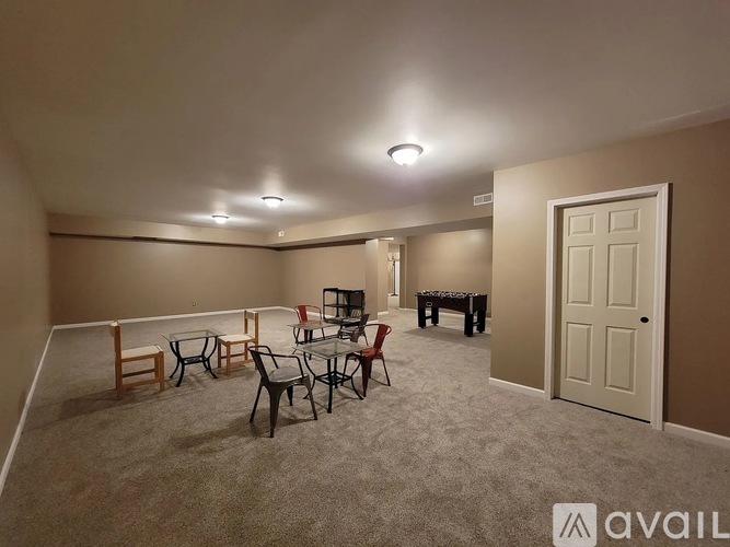 A living room with a grey carpet and furniture.