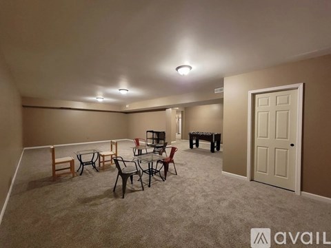 A living room with a grey carpet and furniture.