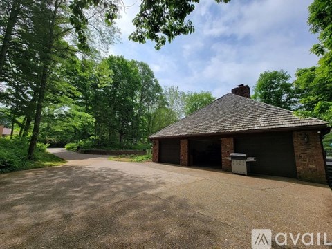 A house with a driveway surrounded by trees.