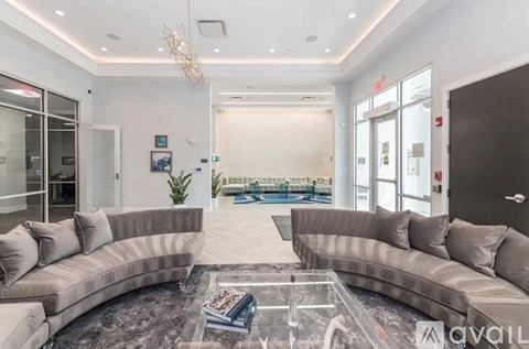 A spacious living room with a large sectional sofa and a glass coffee table.