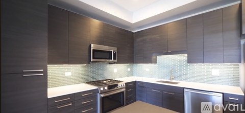 A modern kitchen with dark wood cabinets and a white countertop.