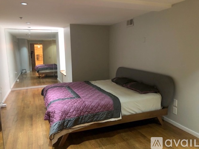 A bedroom with a bed and a purple comforter.