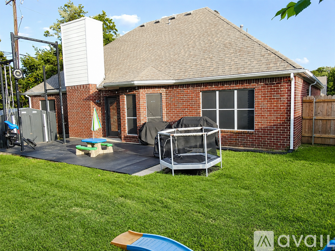 A backyard with a trampoline and a hot tub.