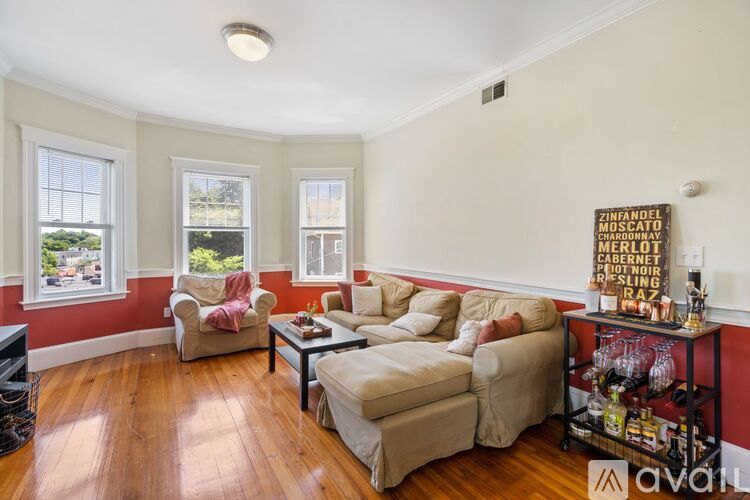 A living room with a white couch and a wooden floor.
