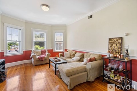 A living room with a white couch and a wooden floor.