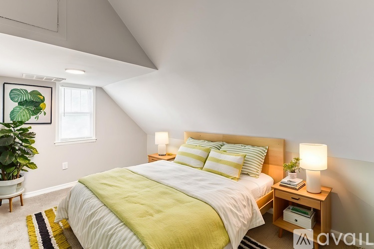 A bedroom with a bed, nightstand, and lamp.