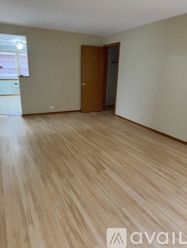 A room with wooden flooring and a door.
