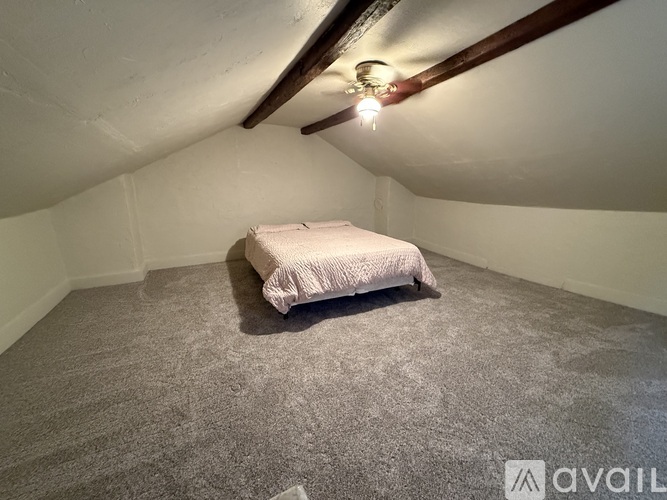 A bedroom with a bed and a ceiling fan.