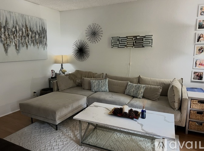 A living room with a grey couch and a white coffee table.