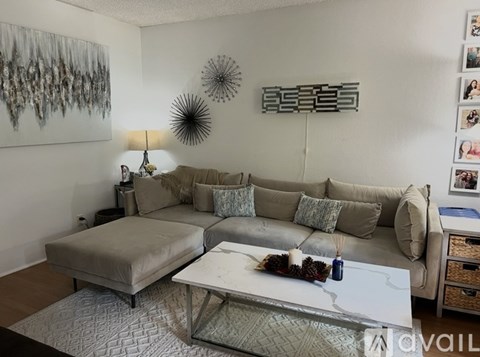 A living room with a grey couch and a white coffee table.