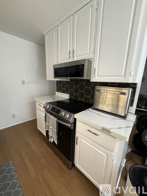 A kitchen with white cabinets and a black stove top.