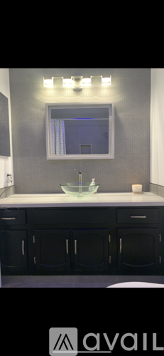 A modern kitchen with black cabinets and a white countertop.