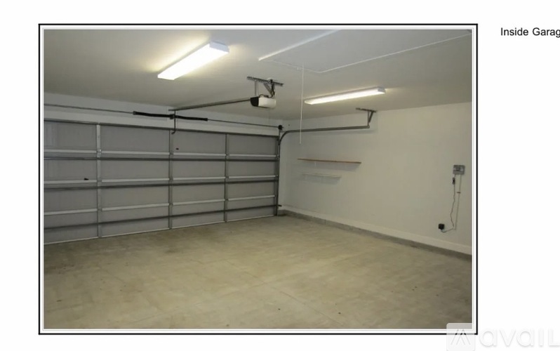 A spacious garage with a white wall and a ceiling light.