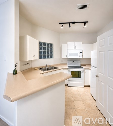 A kitchen with white cabinets and a beige countertop.