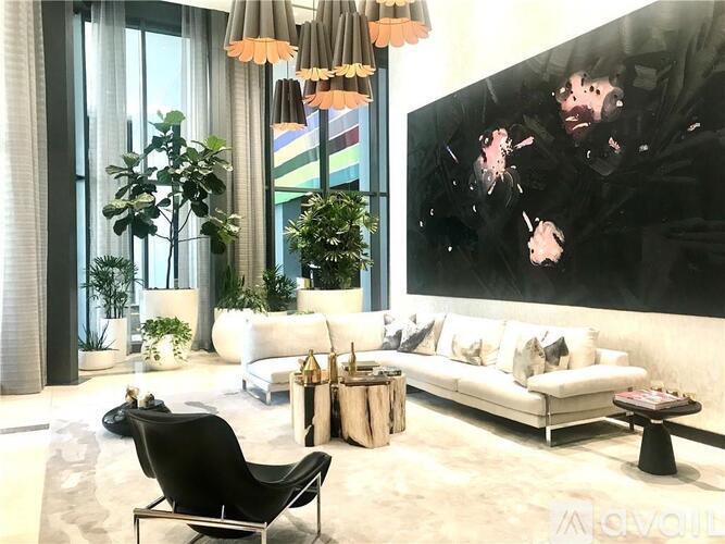 A living room with a black chair and a large painting on the wall.