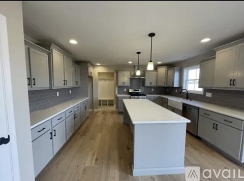 A kitchen with white cabinets and a wooden island.