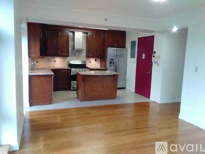 A kitchen with wooden cabinets and a red door.