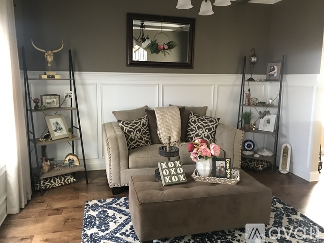 A living room with a brown couch and a mirror above it.