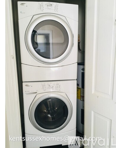 A white washing machine and dryer are stacked on top of each other in a small space.