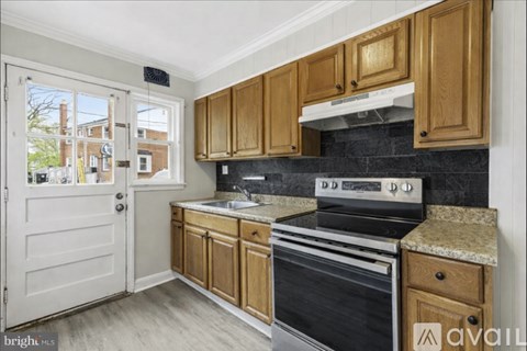 A kitchen with wooden cabinets and a black stove top oven.