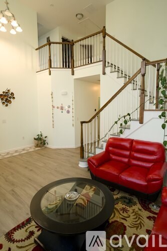 A living room with a red couch and a glass table.
