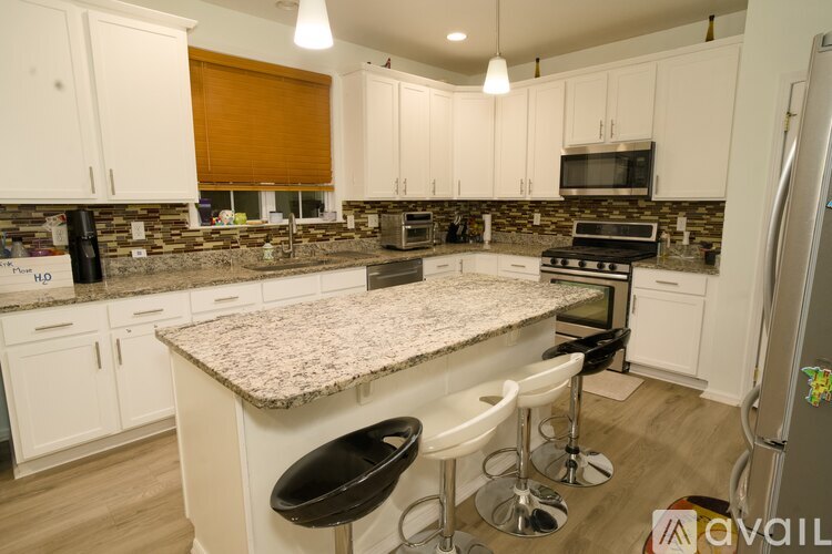 A kitchen with white cabinets and a granite countertop.