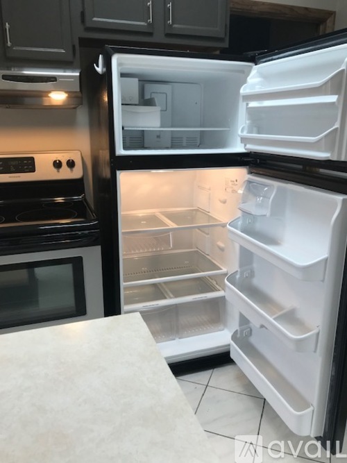 A white refrigerator with its door open in a kitchen.