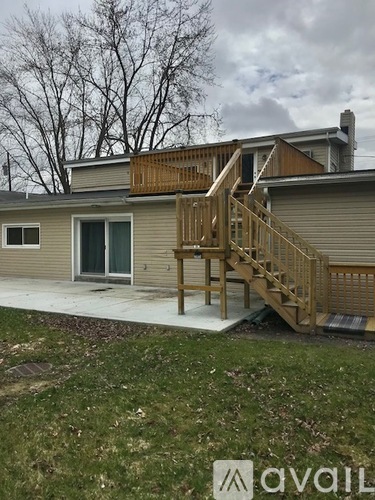 A house with a deck and stairs leading to the second floor.