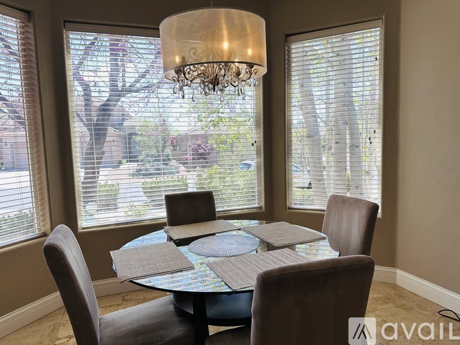 A dining room with a round table and chairs.