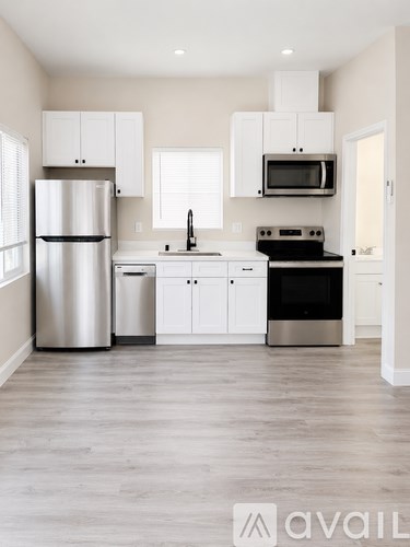 A kitchen with a refrigerator, oven, microwave, and cabinets.