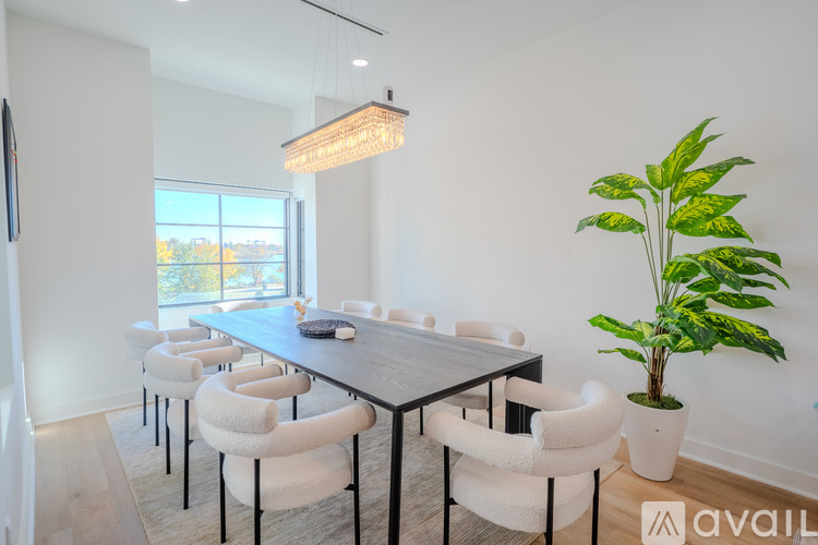 A modern dining room with a long table and chairs.