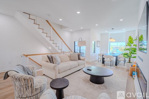 A living room with a white couch and a round table.
