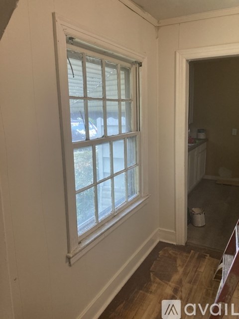 A room with a window and a door leading to another room.