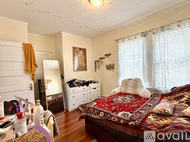 A bedroom with a bed, dresser, and window.