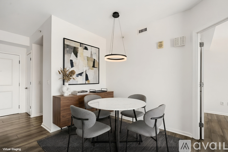 A modern dining room with a white table and grey chairs.