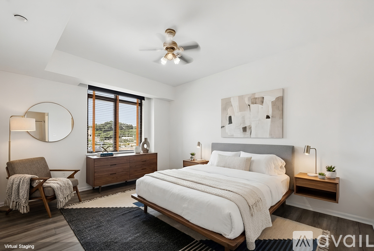 A bedroom with a large bed, a chair, and a ceiling fan.
