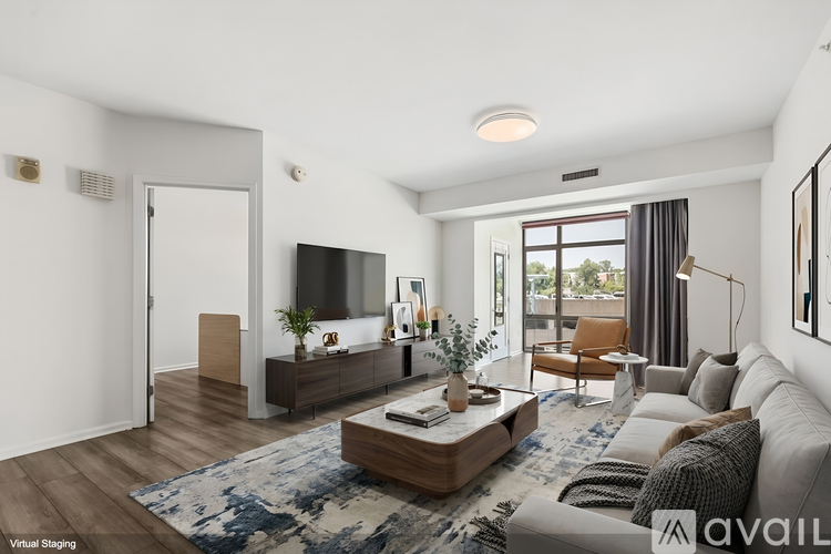 A modern living room with a large couch, a coffee table, and a flat-screen TV.