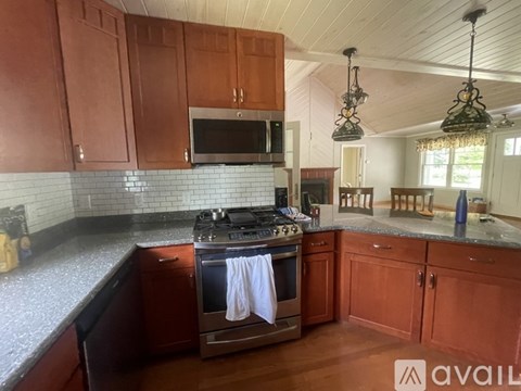 A kitchen with wooden cabinets and a stove top oven.