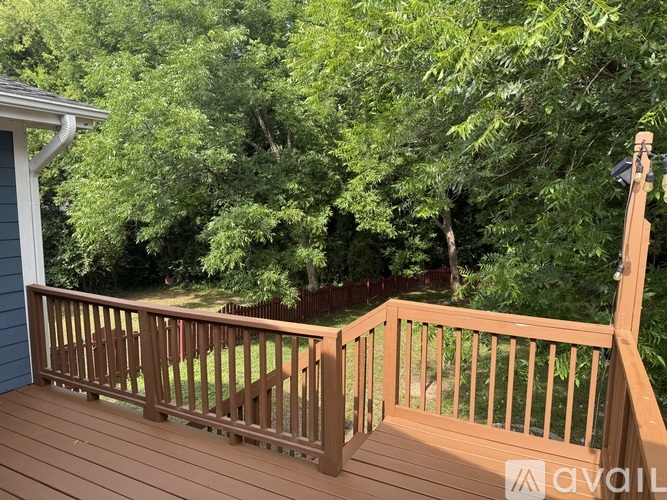 A deck with a railing and trees in the background.