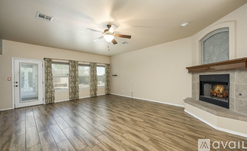 A spacious room with a fireplace and a ceiling fan.