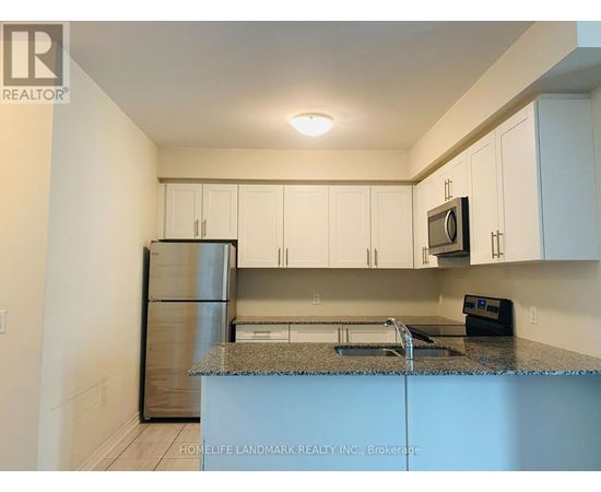 A kitchen with white cabinets and a granite countertop.