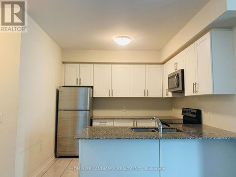 A kitchen with white cabinets and a granite countertop.