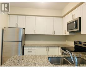 A kitchen with white cabinets and a granite countertop.