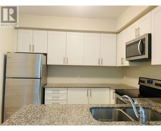 A kitchen with white cabinets and a granite countertop.