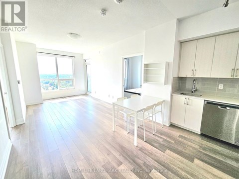 A kitchen with a white table and chairs and a stainless steel refrigerator.